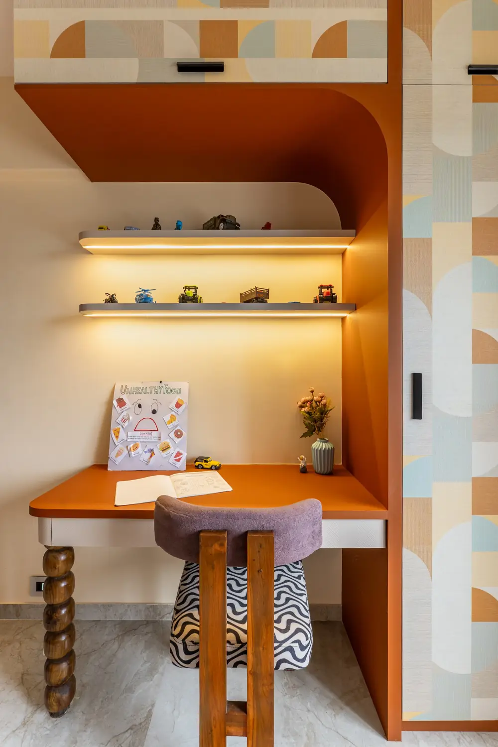 Study nook with lit floating shelves over a terracotta desk