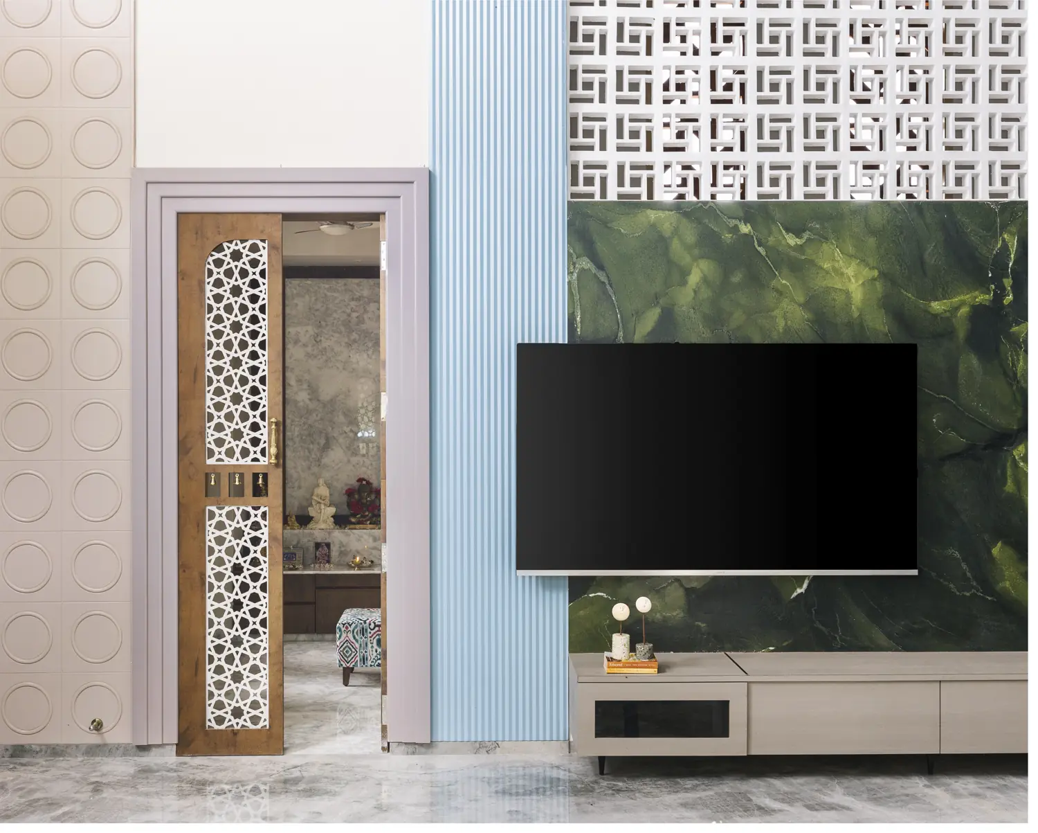 Carved jaali door beside a powder-blue fluted TV wall