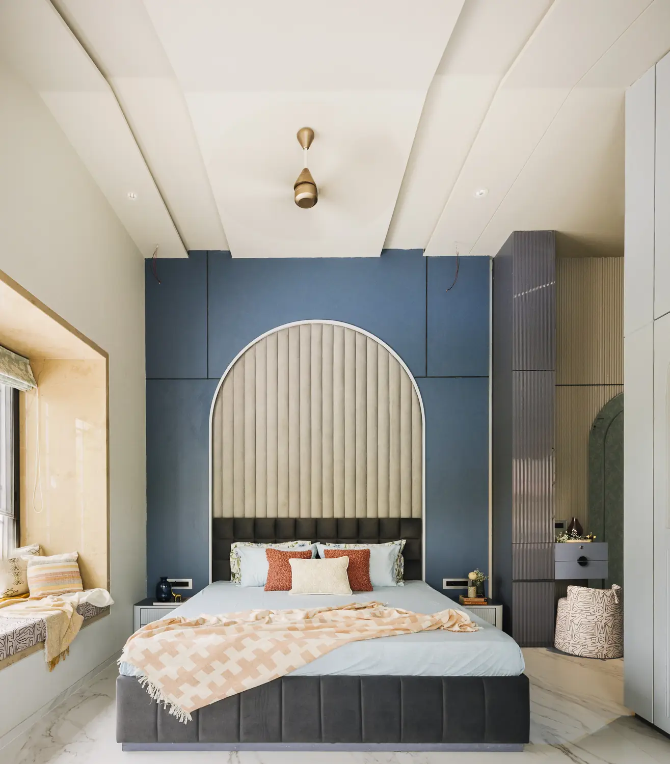 Blue arched headboard wall with a window seat
