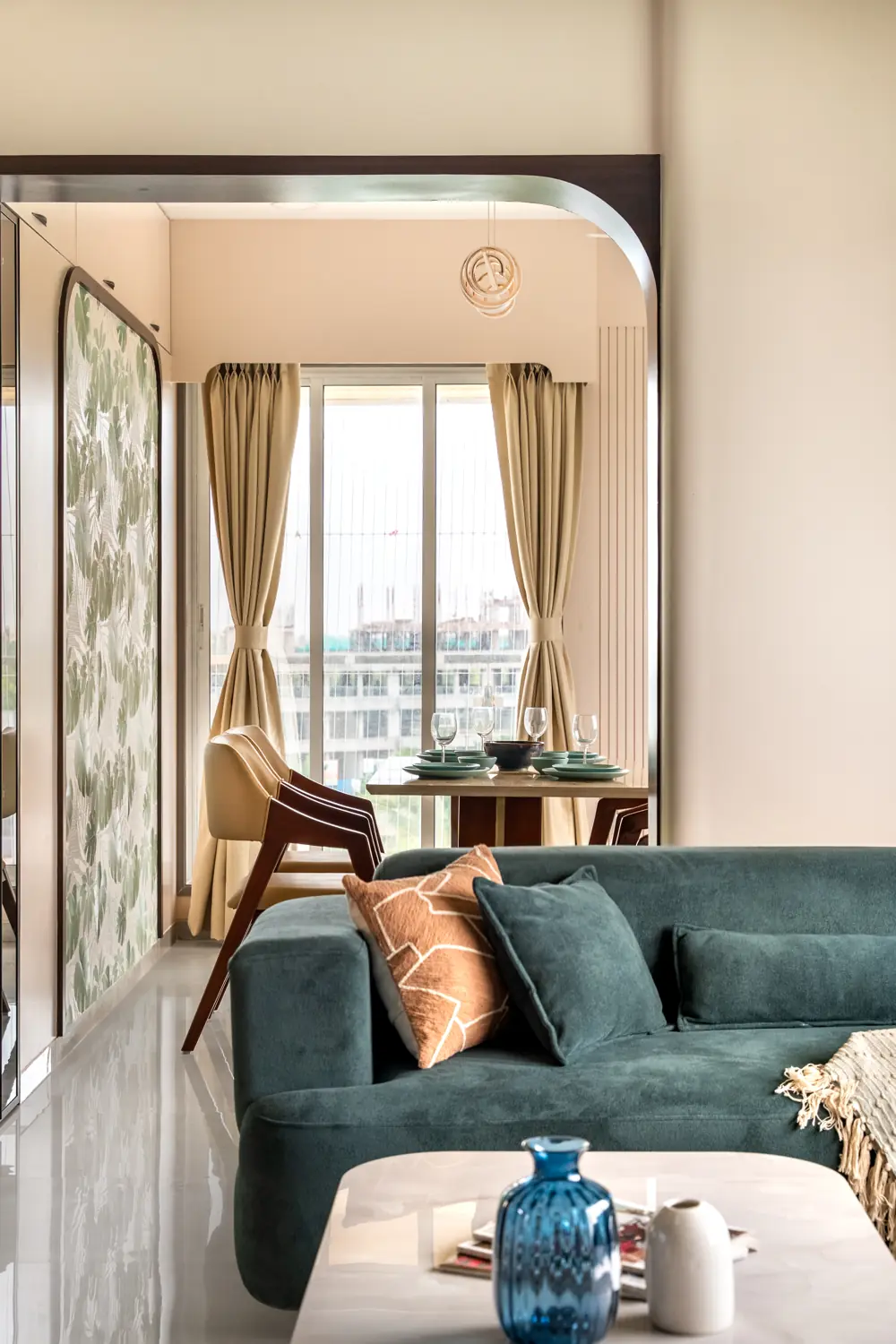 Teal sofa by the window with an arched mirror frame