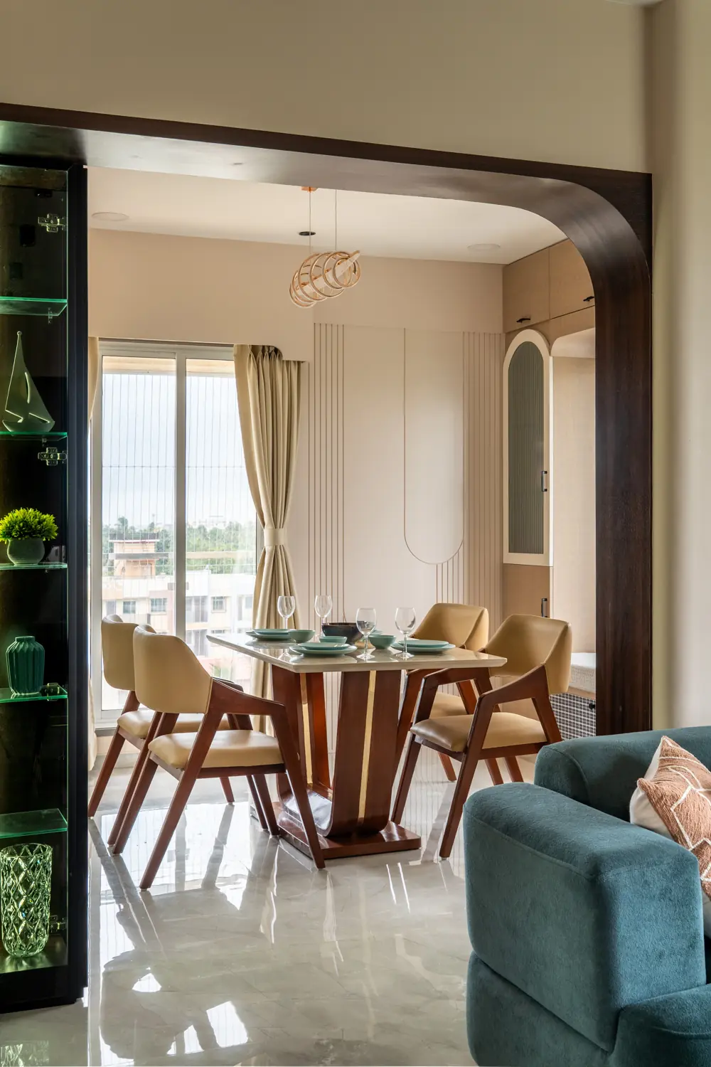 Dining table by the window, seen past a wooden arch