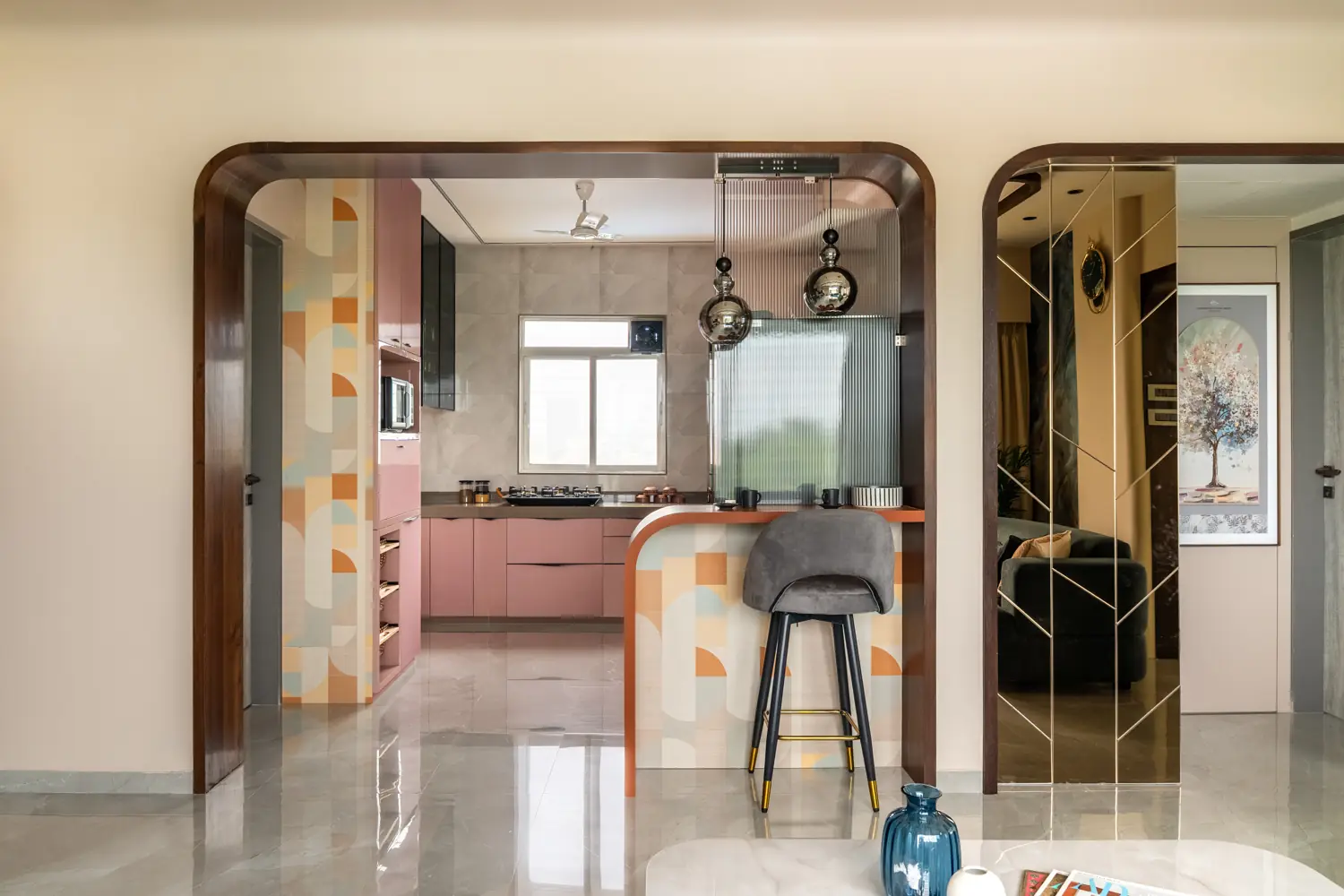 Kitchen seen through two wooden arches, with a terrazzo breakfast counter